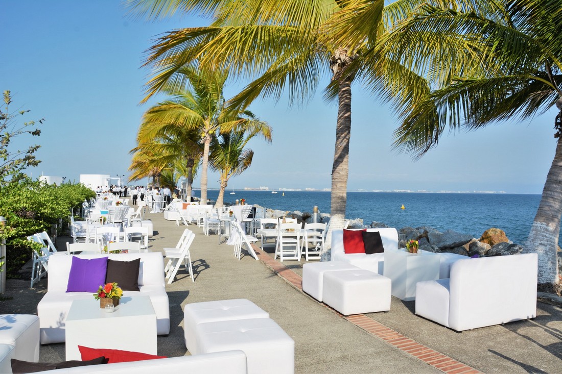 White lounges at the pier with palm trees and blue sky's. 