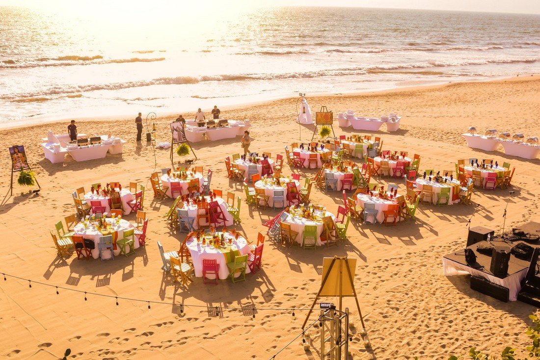 Private event on the beach during a sunset, with colorful Mexican chairs.